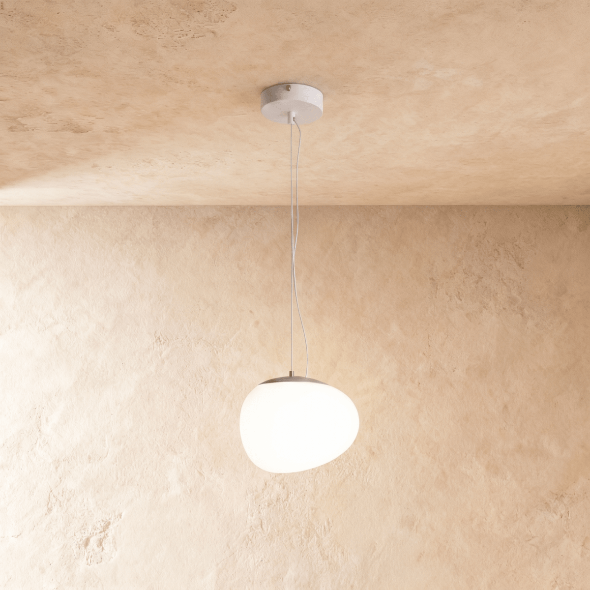 Clérachic glowing white pebble pendant with an uneven rounded shade and a grey metal cap on thin suspension wires