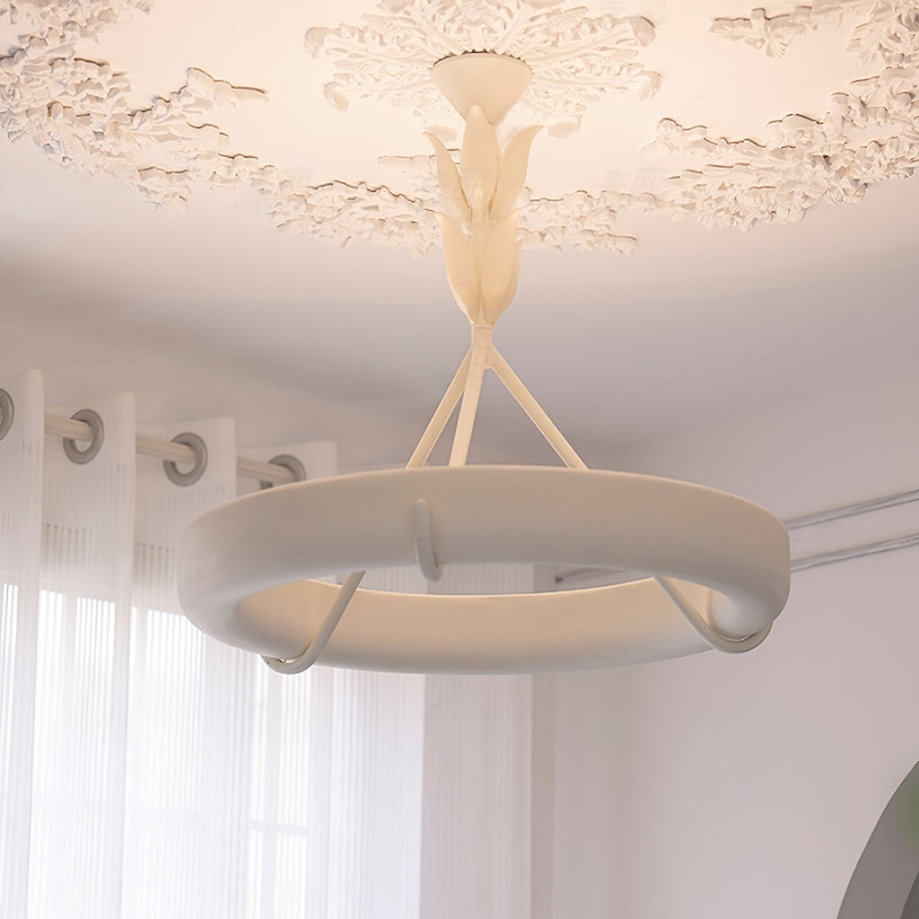 Near view of the lit plaster ring and three struts of this Clérachic ceiling light, with a leaf stem and a plaster rose above.