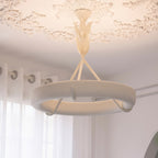 Near view of the lit plaster ring and three struts of this Clérachic ceiling light, with a leaf stem and a plaster rose above.