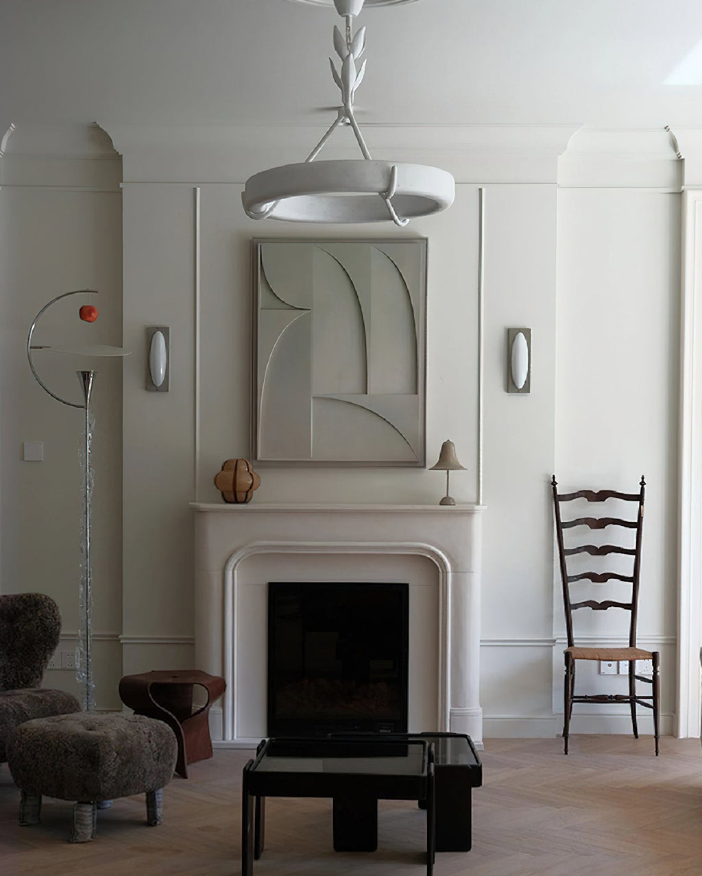 Clérachic ceiling light high in a panelled room, above a fireplace with a carved relief panel and a ladder-back chair.