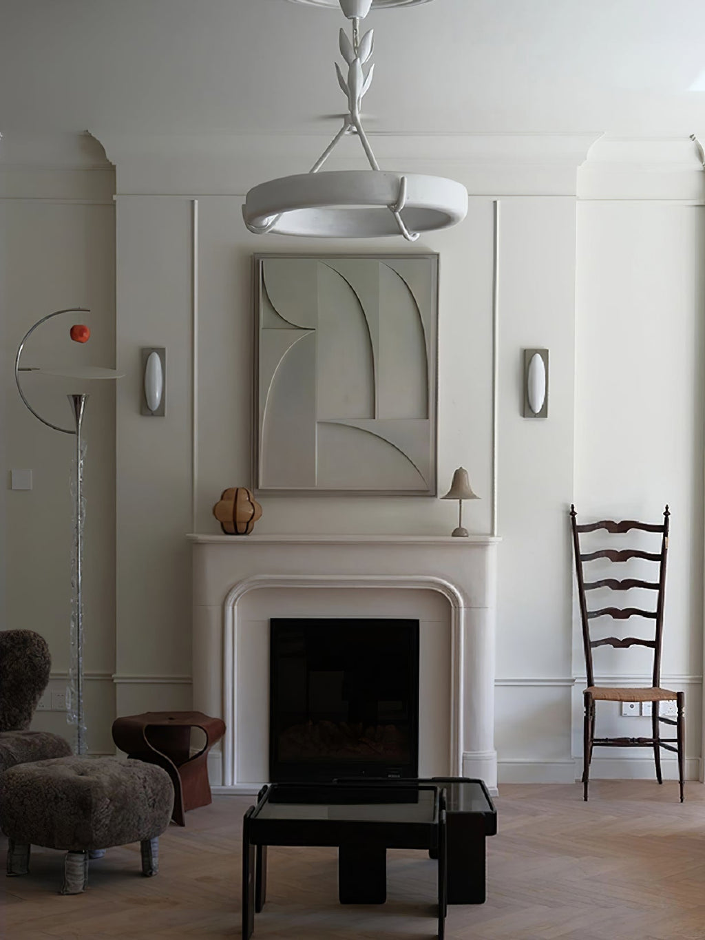 This Clérachic ceiling light seen from below in a tall room, above a white fireplace with a relief panel and a woolly stool.