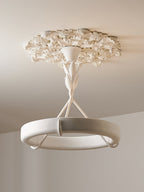 Looking up at the plaster ring, three struts and rose of this Clérachic ceiling light, with a plain wall in the background.