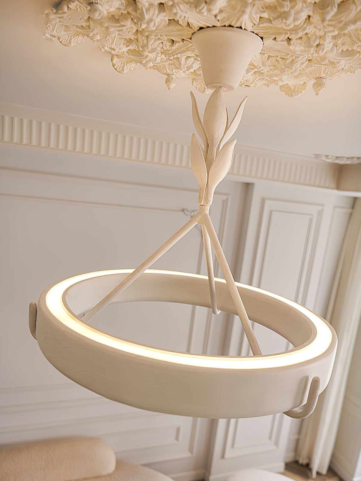 Close view of the lit plaster ring and leaf-wrapped stem of this Clérachic ceiling light, with a ceiling rose above.