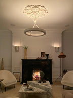 Lit Clérachic ceiling light under a plaster rose in the evening, with a fire burning in the fireplace below it.