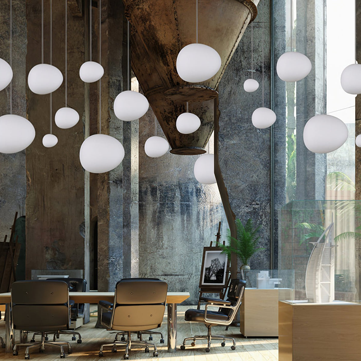 Many white pebble-shaped Clérachic glass pendants hang at varied heights in a tall industrial space with a concrete hopper.