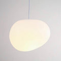 Close view of the glowing satin glass of a single Clérachic pebble pendant, with a soft, even warm light.