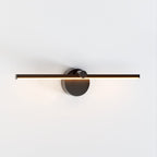 Clérachic wall lamp in matte black photographed head-on, its slim bar glowing warm white on a plain background.