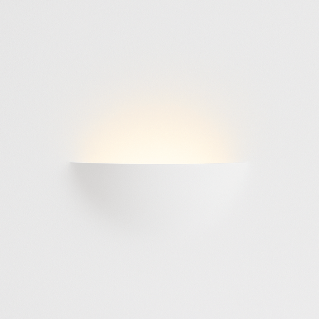 Clérachic trimless wall light glows softly, its plaster-finish shade blending flush into the wall.