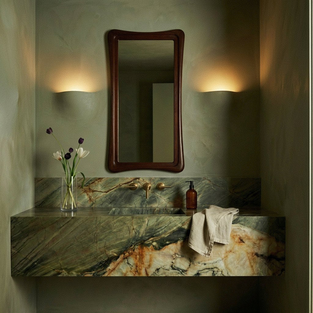Two Clérachic trimless wall lights flank a wooden mirror above a green marble bathroom vanity.