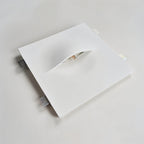 An angled view of the Clérachic trimless wall light's square plaster plate and mounting clips.