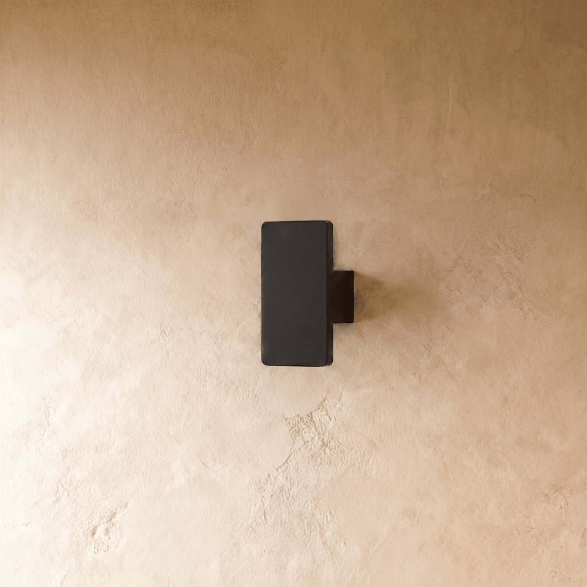 Unlit view of the Clérachic black wall light shows its compact rectangular block mounted flush to plaster.