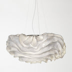 The widest Clérachic pendant shade in the set, with deep layered folds, hung on thin wires against a light grey backdrop.