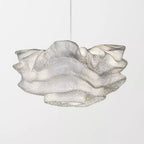 Close side view of the pleated, perforated mesh on this Clérachic pendant, with one hanging cord above.