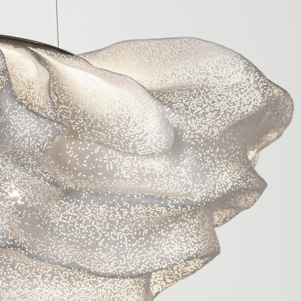 Close view of the perforated mesh on this Clérachic pendant, with a folded ridge catching the light.