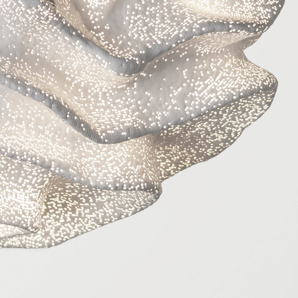 Close view of the frilled lower edge of this Clérachic pendant, its fine mesh dots lit from within.