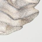 Close view of the frilled lower edge of this Clérachic pendant, its fine mesh dots lit from within.