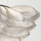 A tighter crop of the folded ridge on this Clérachic pendant, with tiny perforations scattered across the mesh.