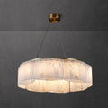 Clérachic Willamette Alabaster Drum Chandelier lit in a grey plaster room, its stone panels glowing honey-amber.