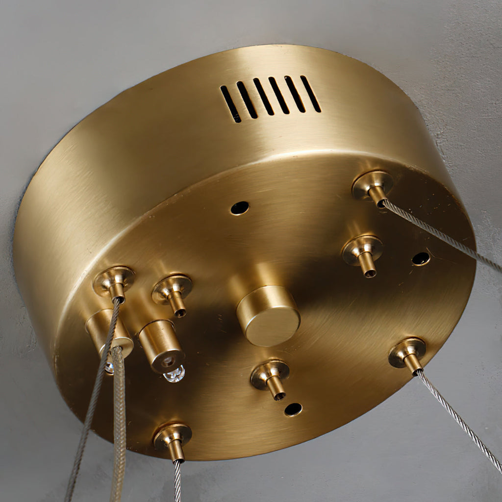 Close-up of the brushed-brass canopy on the Clérachic Willamette Alabaster Drum Chandelier, with its steel-cable grips.
