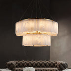 The Clérachic Willamette Alabaster Drum Chandelier lit above a tufted sofa in a dark marble lounge.