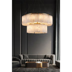 The two-tier Clérachic Willamette Alabaster Drum Chandelier lighting a panelled salon above grey velvet sofas.