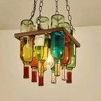 Close-up of the Clérachic wine bottle chandelier's peaked frame, wine labels and a glowing filament bulb visible among the glass necks.