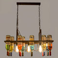 Overhead view of the Clérachic Wine Bottle Glass Pendant Light, filament bulbs glowing among mixed glass bottles.