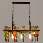 Overhead view of the Clérachic Wine Bottle Glass Pendant Light, filament bulbs glowing among mixed glass bottles.