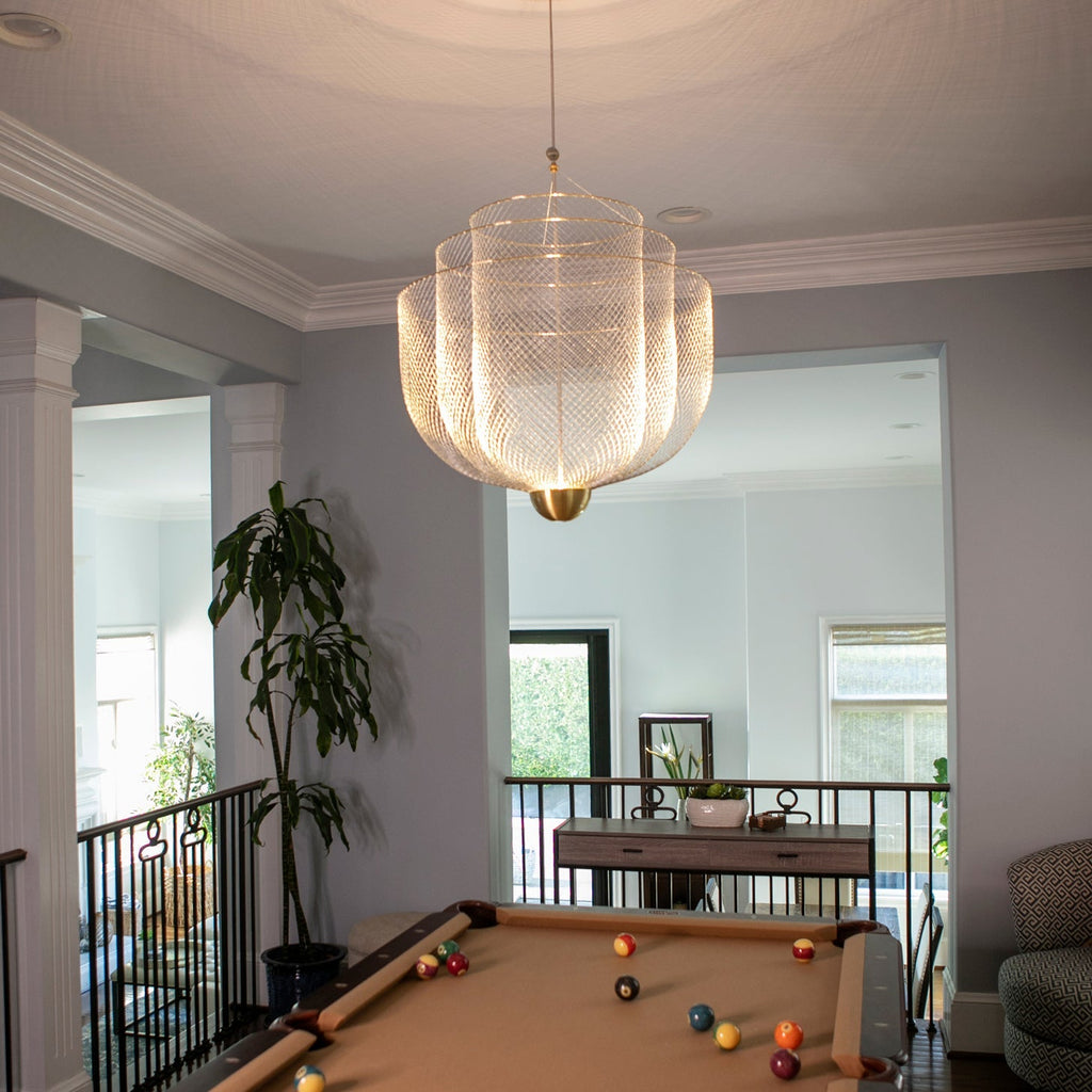 Clérachic wire-mesh chandelier in a hallway with cream mouldings, a pool table and a tall indoor plant beyond.