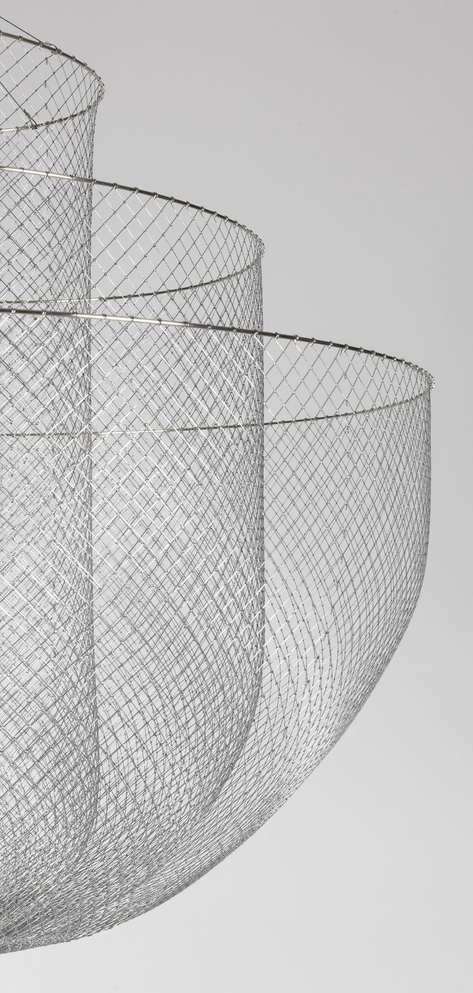 Side view of the wire-mesh bowls of this Clérachic chandelier, seen against a pale grey backdrop.