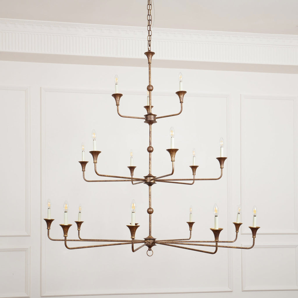 Clérachic's Wisp Grande chandelier centered head-on, all three lit tiers spreading wide above a paneled room.