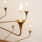 Clérachic's Wisp Grande chandelier up close, two Edison-style filament bulbs lit in their bronze sockets.
