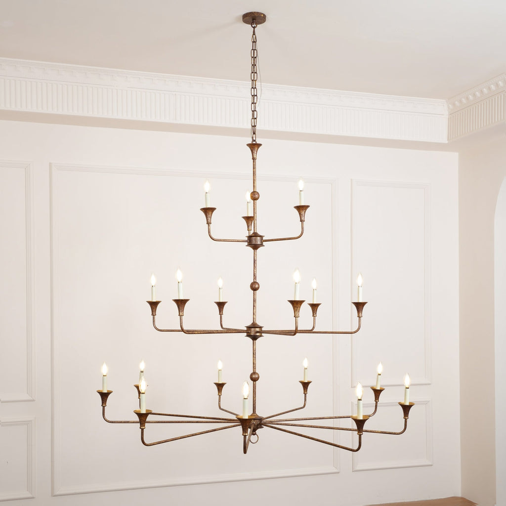 Clérachic's Wisp Grande chandelier drops on a longer chain in this wide shot, all 18 arms lit above a wood floor.