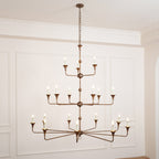 Clérachic's Wisp Grande chandelier drops on a longer chain in this wide shot, all 18 arms lit above a wood floor.