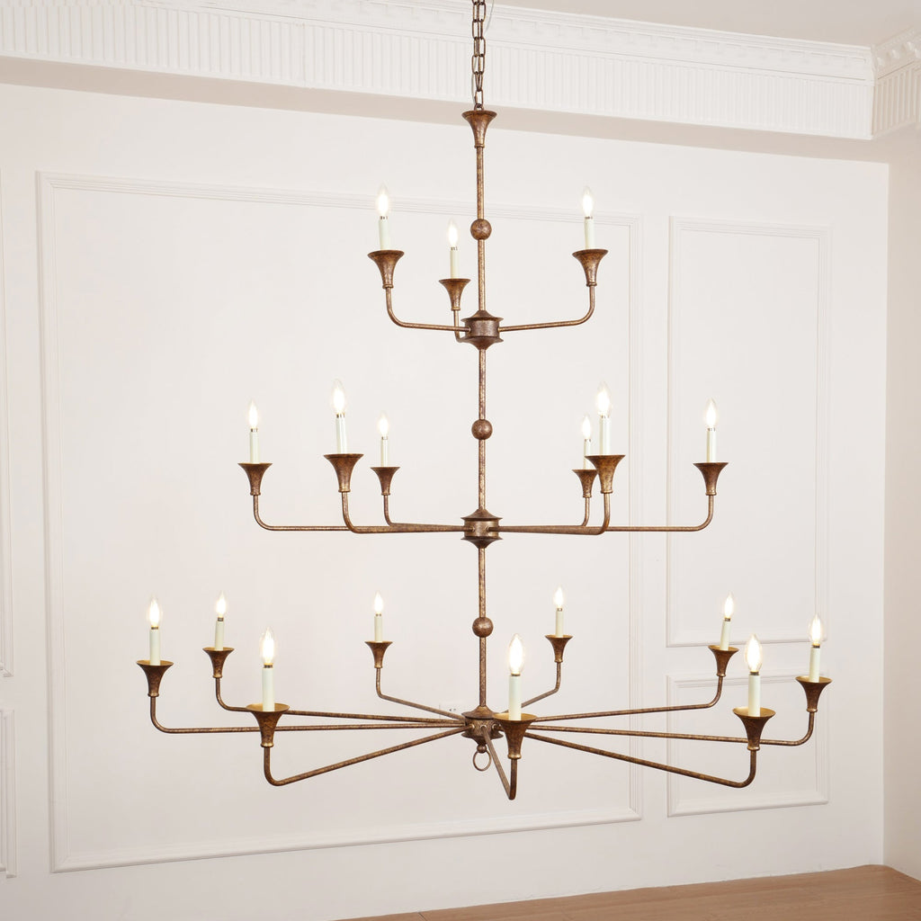 Clérachic's Wisp Grande chandelier closes the gallery with its 18 lit arms glowing warm in a paneled room.