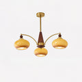 Clérachic Wood and Brass Chandelier in caramel glass, three lit shades on curved arms below a turned wood cone.