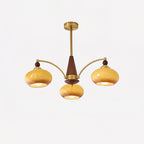 Clérachic Wood and Brass Chandelier in caramel glass, three lit shades on curved arms below a turned wood cone.