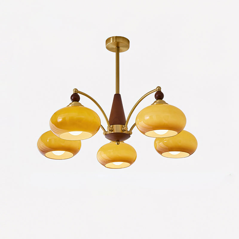 Clérachic Wood and Brass Chandelier in caramel glass, five honey-toned shades lit around a short brass rod.