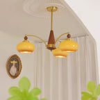 Clérachic Wood and Brass Chandelier in caramel seen from below, three amber shades warming a quiet corner.