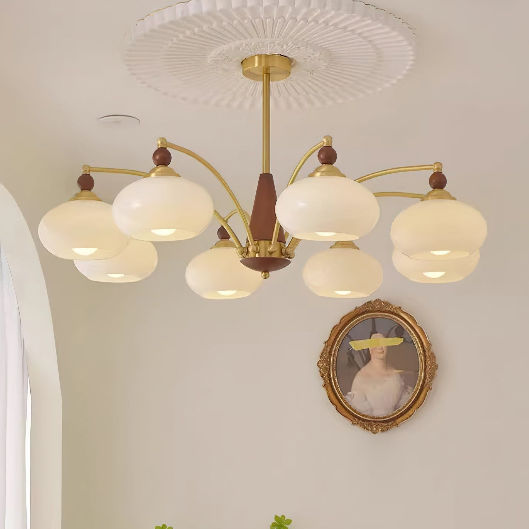 Clérachic Wood and Brass Chandelier in white, eight shades spreading soft cream light across a pale wall.