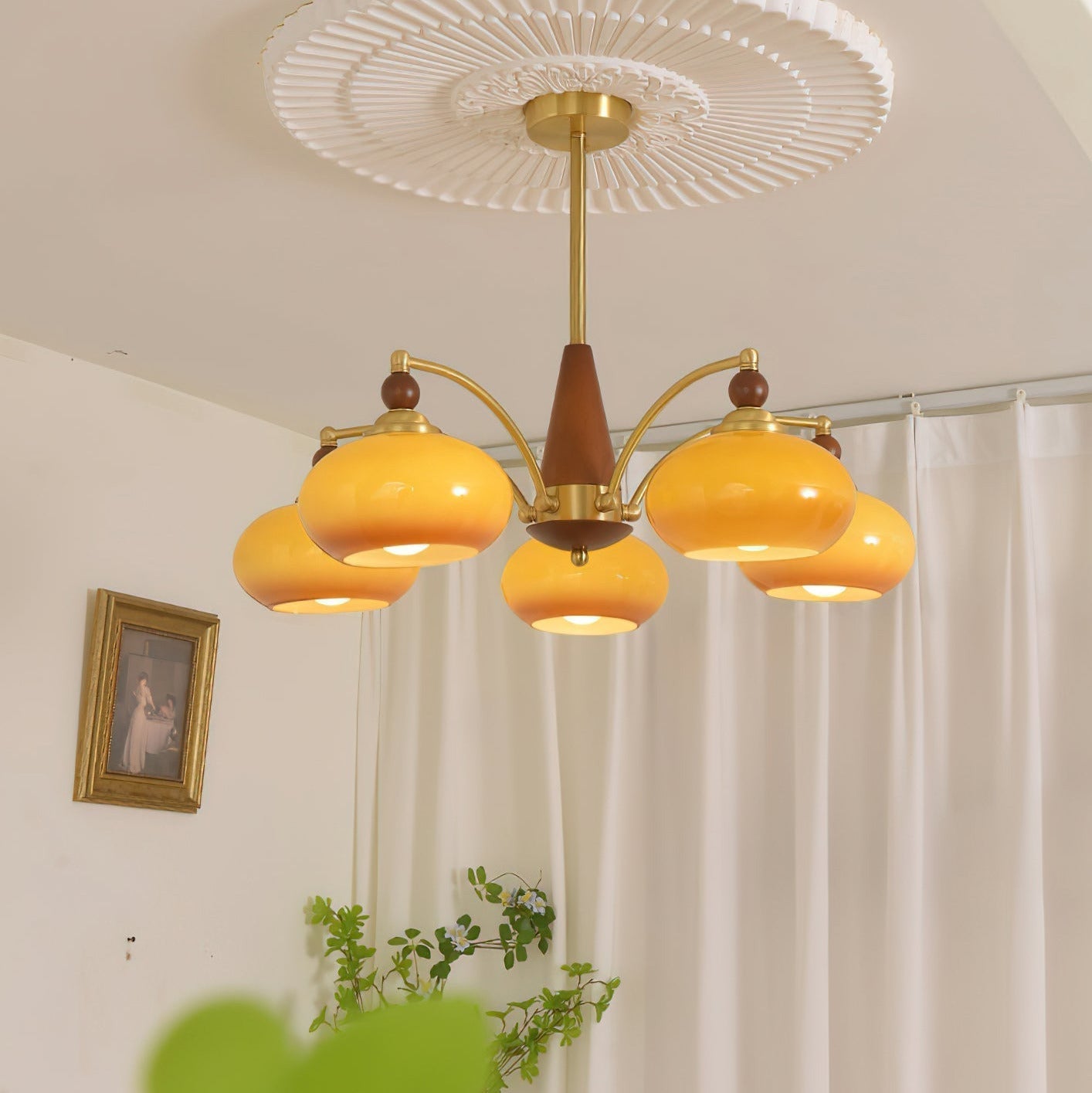Clérachic Wood and Brass Chandelier in caramel glass, five lit shades over a curtained corner of a room.