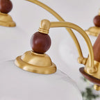 Close-up of the Clérachic Wood and Brass Chandelier collar, a wood bead seated on a brass cap above the glass.