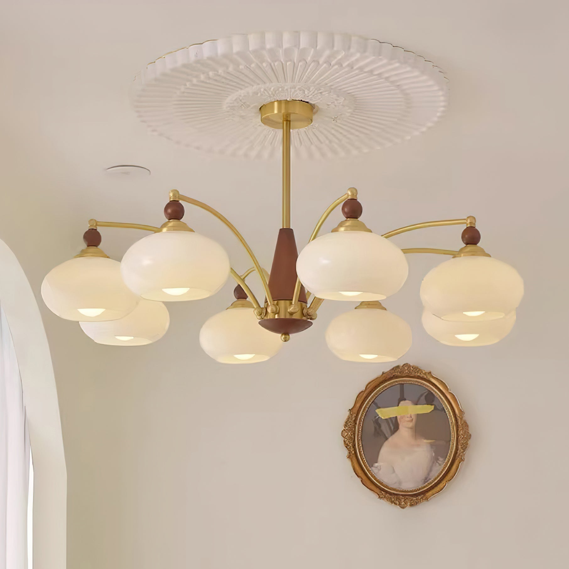 Clérachic Wood and Brass Chandelier in white, eight shades spreading cream light across a pale wall.