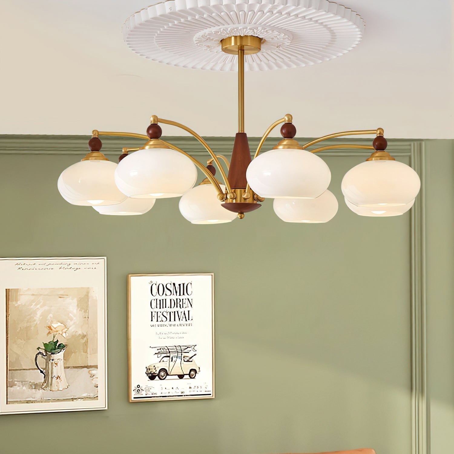 Clérachic eight-light Wood and Brass Chandelier in white glass, hung before a sage wall and framed prints.