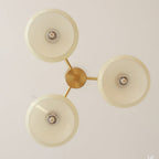 Seen from directly below, the Clérachic three-light chandelier shows three glass discs around a brass hub.