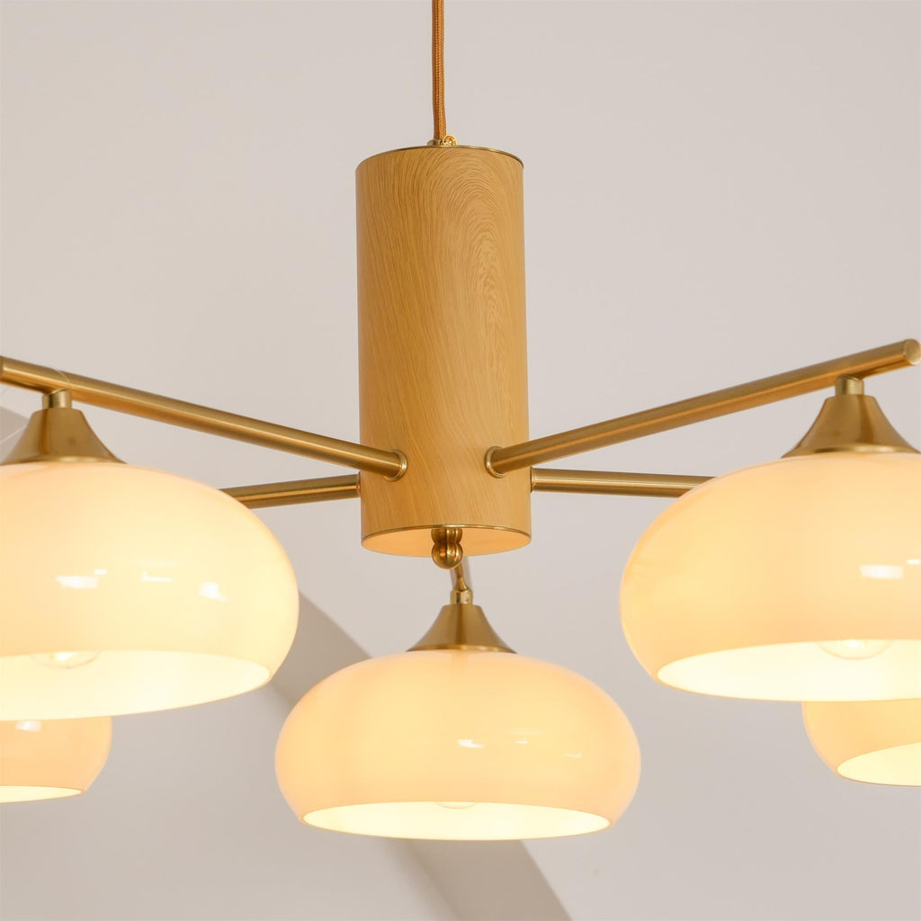 Close view of the turned wood cylinder on the Clérachic chandelier, brass rods pushed through to the lit shades.