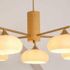 Close view of the turned wood cylinder on the Clérachic chandelier, brass rods pushed through to the lit shades.