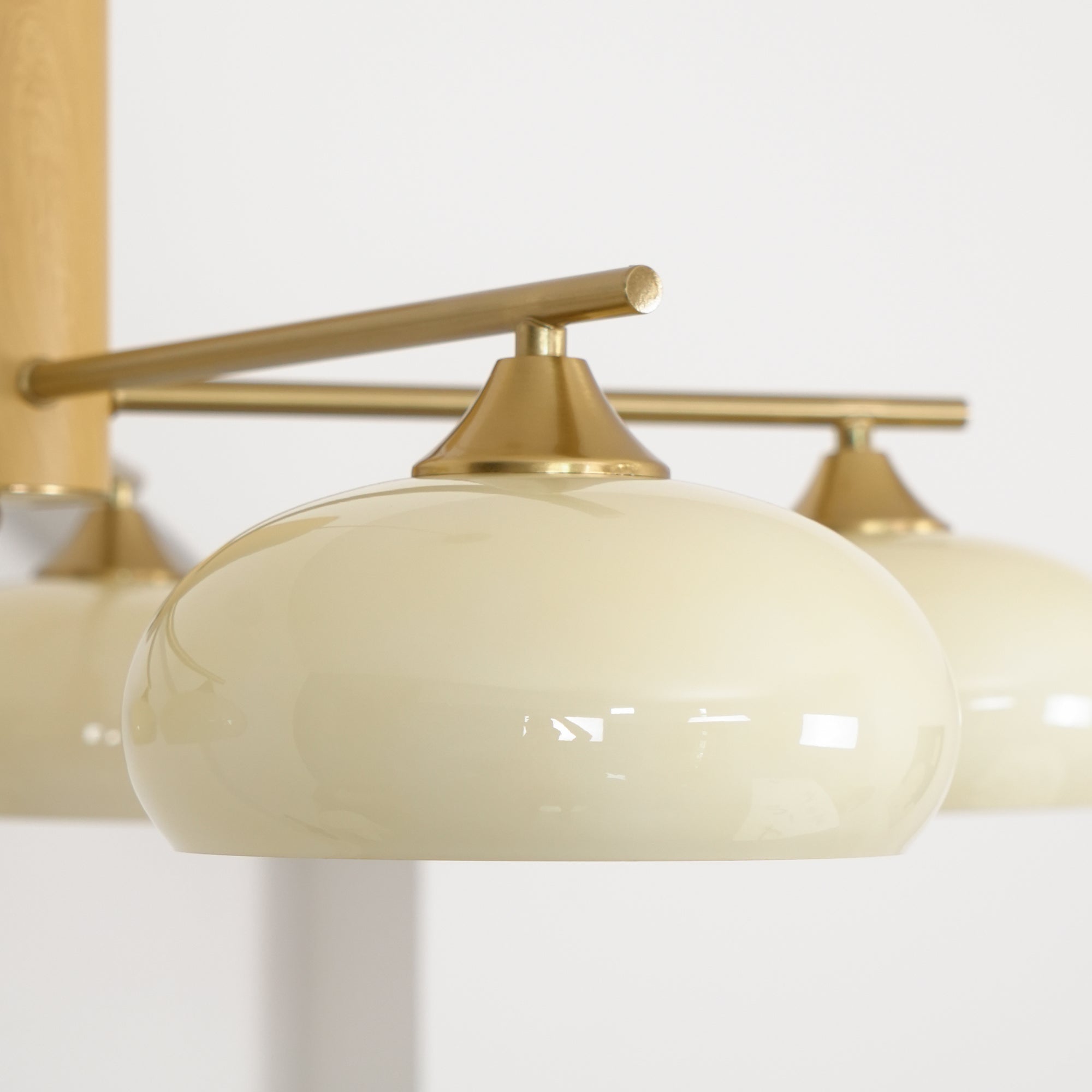 One beige persimmon shade of the Clérachic chandelier seated in its brass cone fitter on a slim rod.