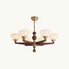 A Clérachic chandelier with cream glass shades on turned wood arms and brass fittings, shown on a plain white backdrop.