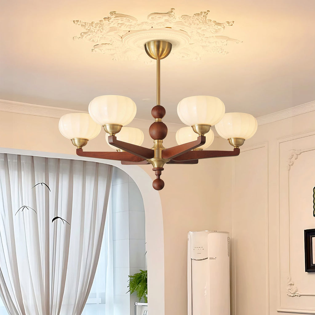 Warm light from the cream glass shades of this Clérachic chandelier fills a room with sheer curtains and cream wall panelling.